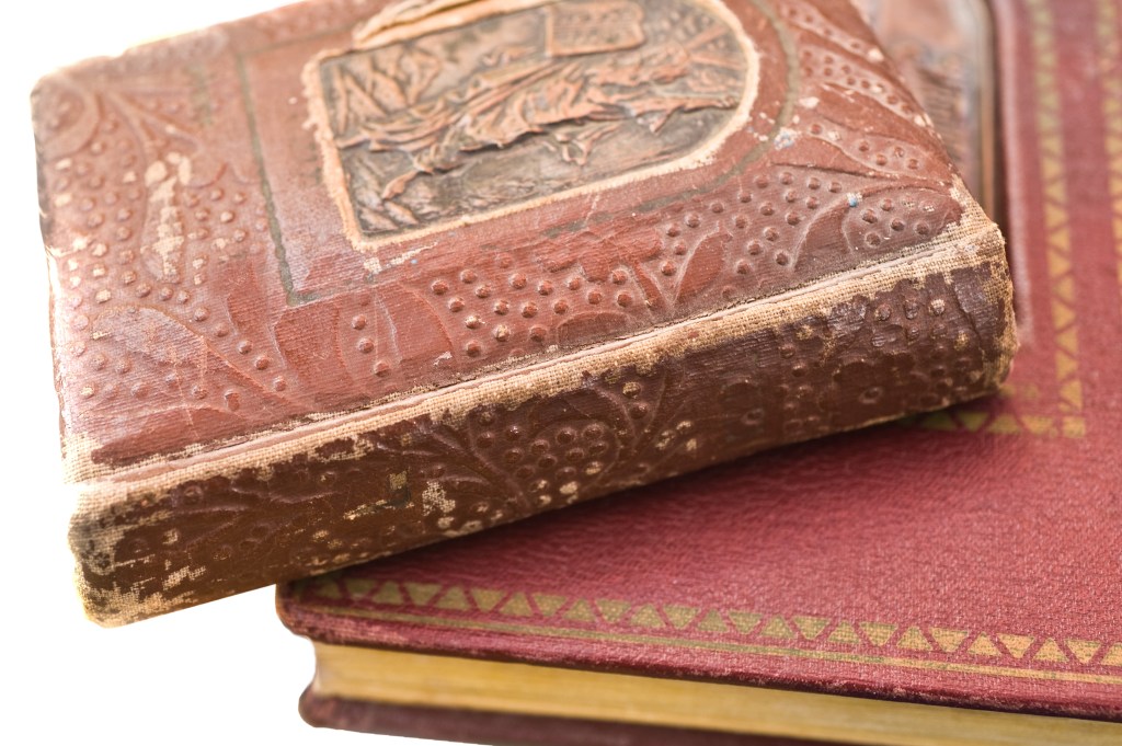 Three old red books in a small pile